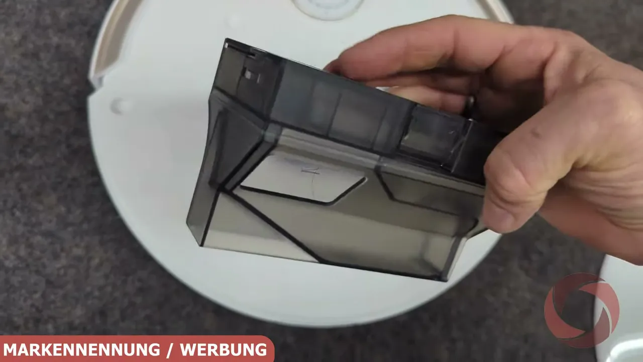 Der transparente Staubauffangbehälter lässt sich nach Abnehmen der oberen Abdeckung einfach mit der Hand entnehmen.